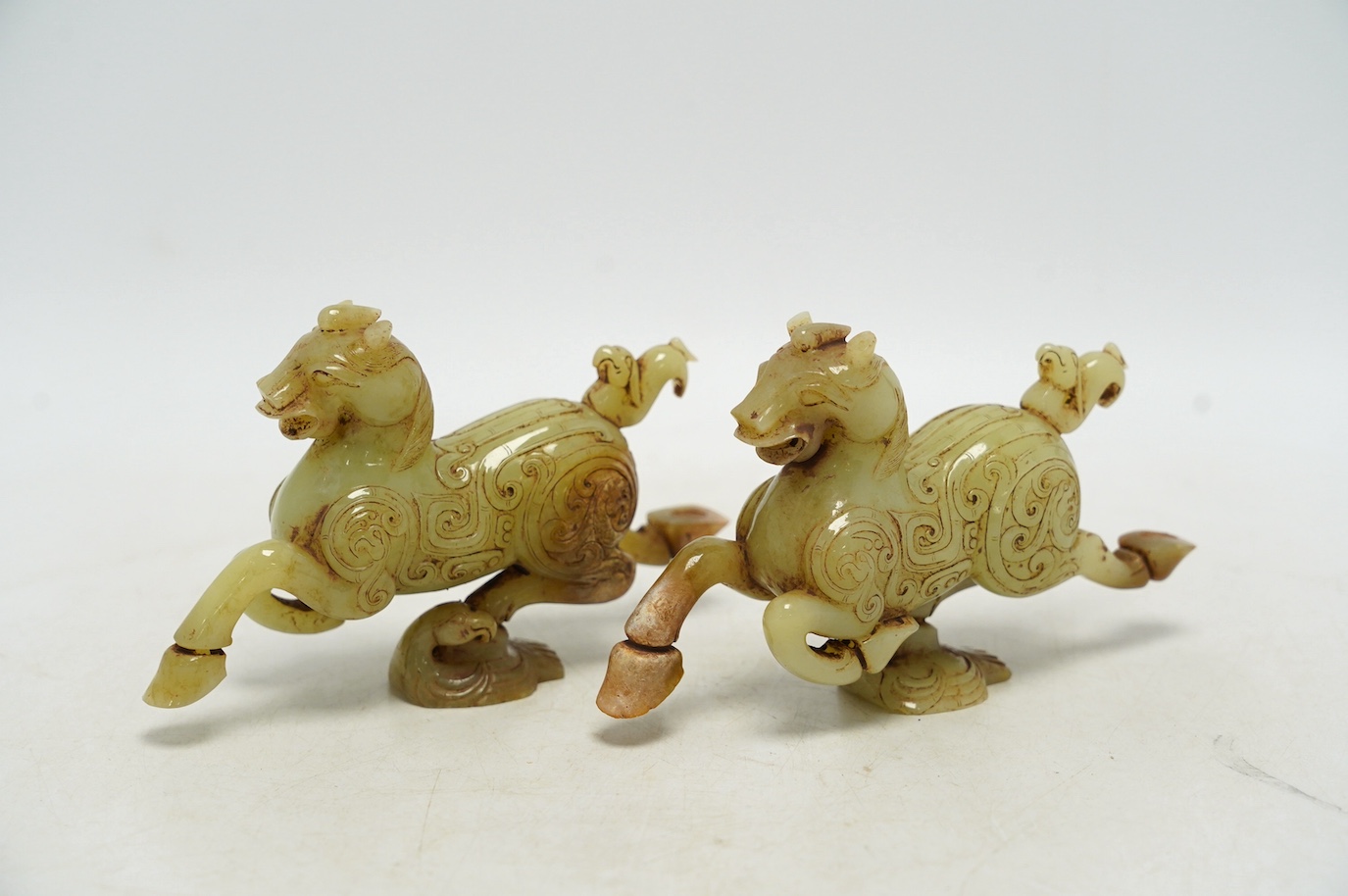 A pair of Chinese green jade horses, Han style, cased, 15cm wide. Condition - good